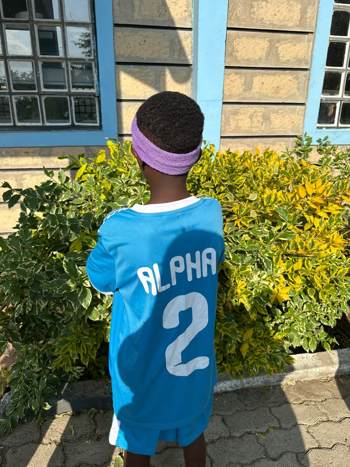 A young player seen from behind in his blue SMCH kit, number 2