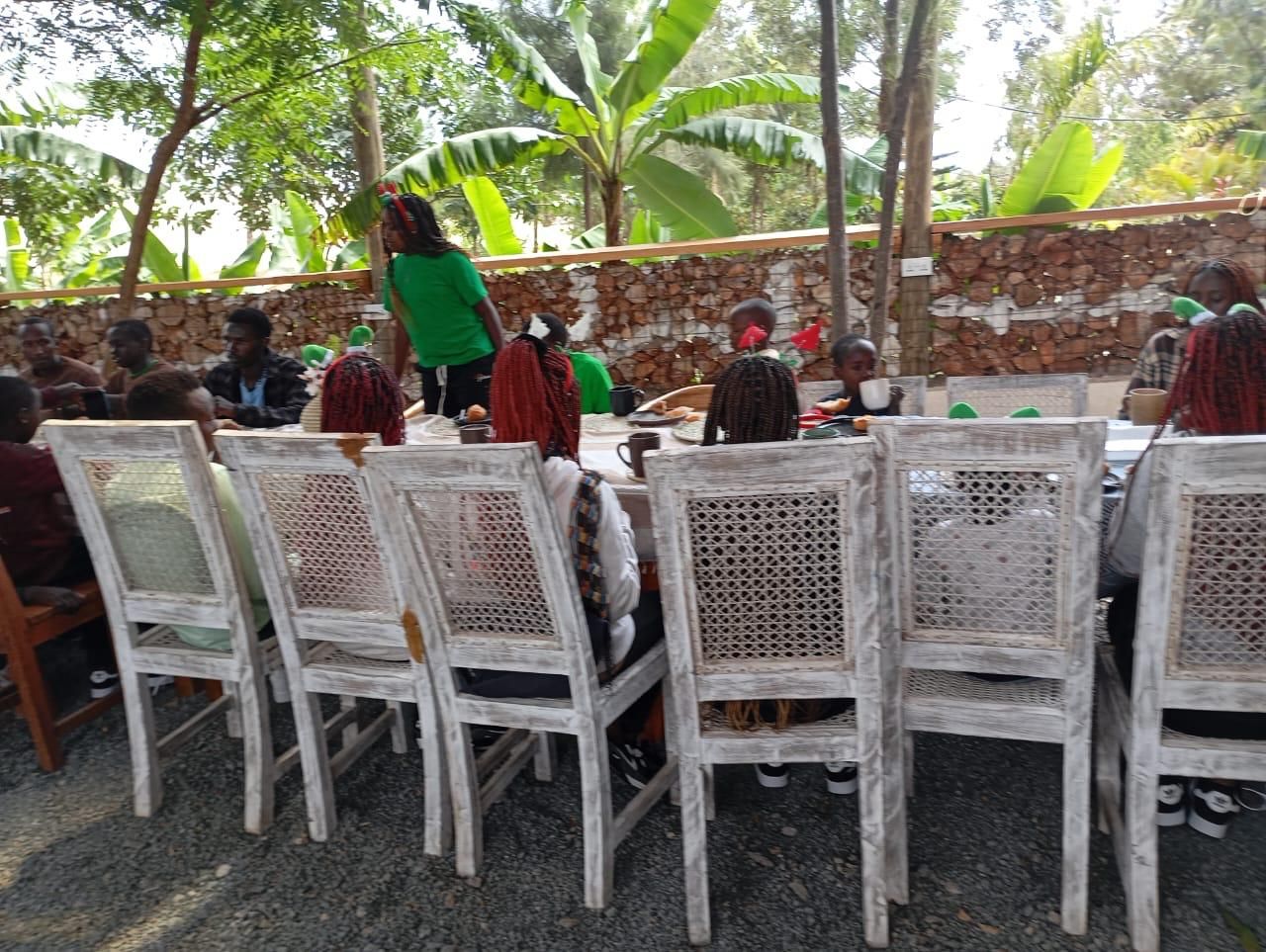 Children and caregivers sharing a meal outdoors